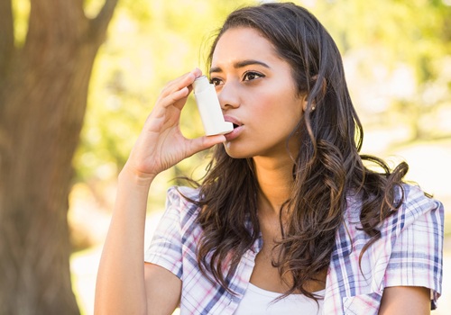 Brünette Frau mit Asthma Inhalator