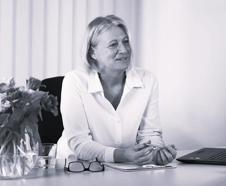 Heilpraktikerin Simone Munz am Schreibtisch sitzend