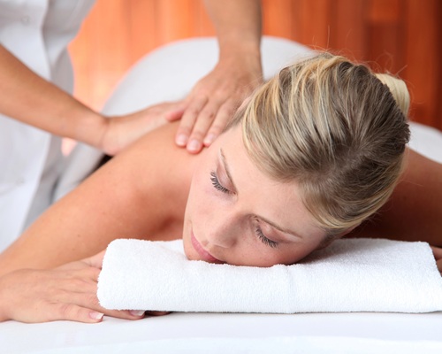 nahaufnahme einer schönen blonden Frau, die eine rückenmassage erhält