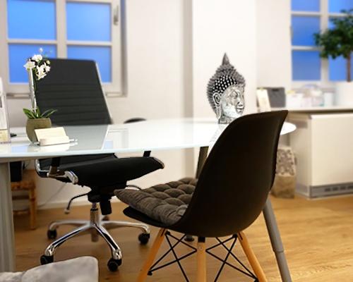 Schreibtisch mit zwei Stühlen für die Besprechung im Behandlungszimmer der Naturheilpraxis Munz